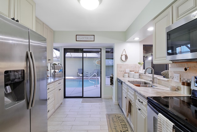 kitchen featuring appliances with stainless steel finishes, backsplash, and sink