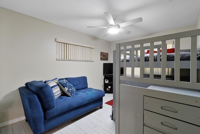 interior space featuring a textured ceiling, light hardwood / wood-style floors, and ceiling fan