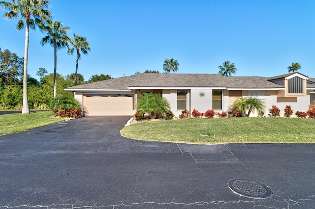 single story home featuring a garage and a front yard