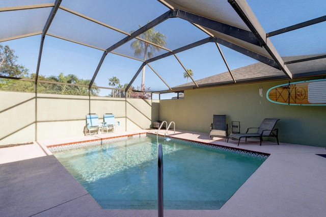 view of swimming pool featuring glass enclosure and a patio