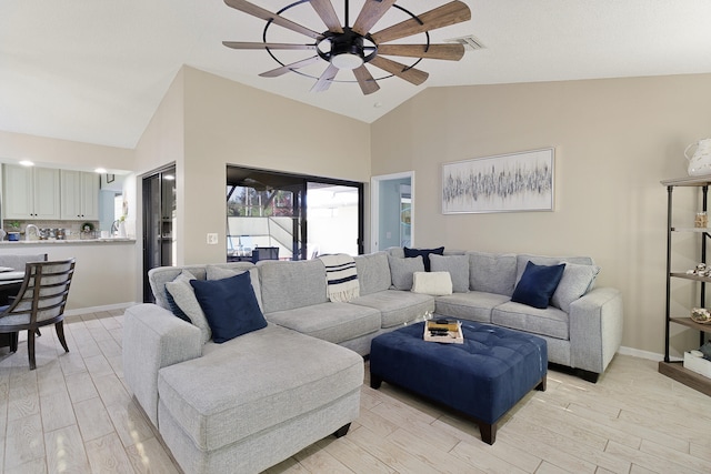 living room featuring ceiling fan, light hardwood / wood-style flooring, and vaulted ceiling