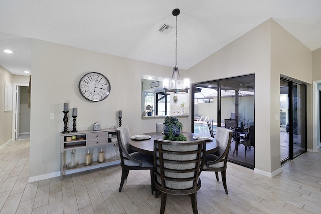 dining area featuring a chandelier, light hardwood / wood-style flooring, and lofted ceiling