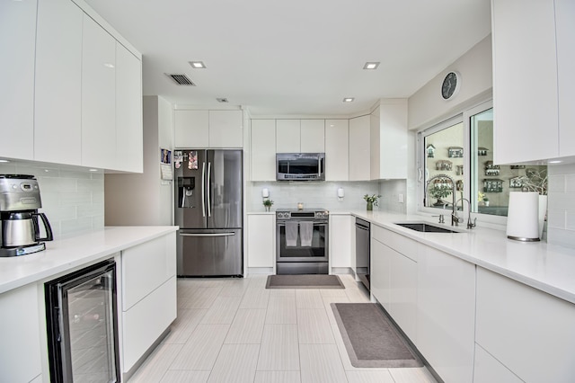 3961 NW 27th Ave, Boca Raton, FL 33434 - kitchen with stainless steel appliances, beverage cooler, modern cabinets, and tasteful backsplash