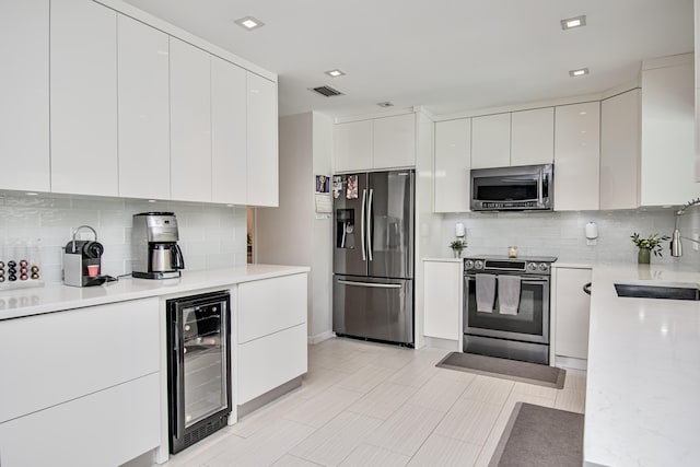3961 NW 27th Ave, Boca Raton, FL 33434 - kitchen featuring stainless steel appliances, wine cooler, modern cabinets, tasteful backsplash, and white cabinetry