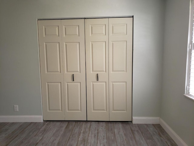 unfurnished bedroom featuring a closet and hardwood / wood-style floors