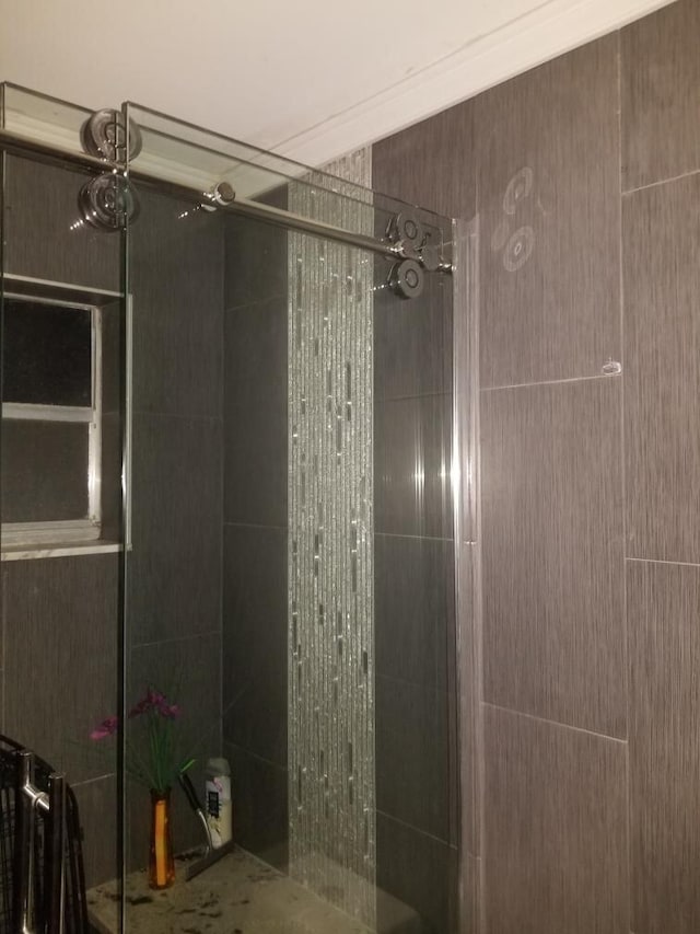 bathroom with an enclosed shower and ornamental molding