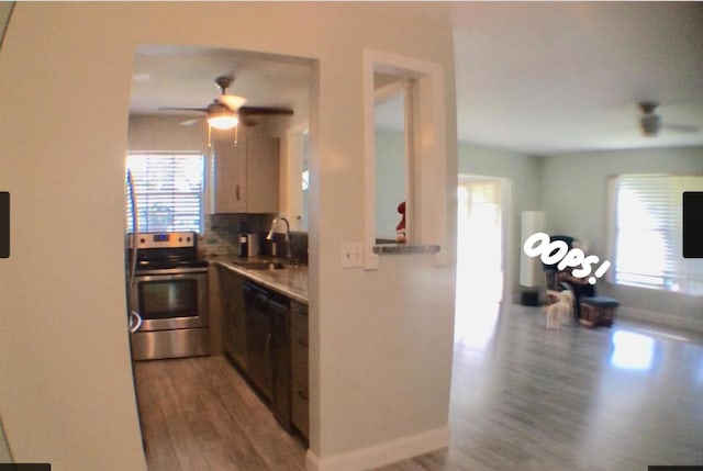 kitchen with electric stove, backsplash, wood-type flooring, sink, and black dishwasher