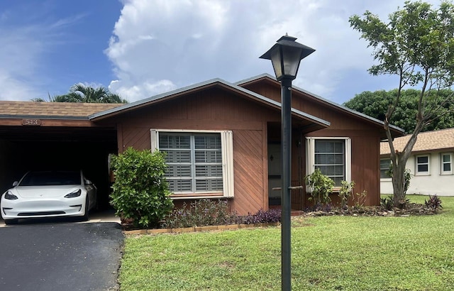 view of front facade featuring a front lawn and a carport