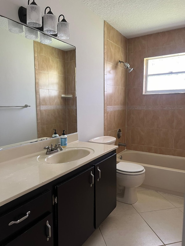 full bathroom featuring tile patterned floors, vanity, a textured ceiling, tiled shower / bath combo, and toilet