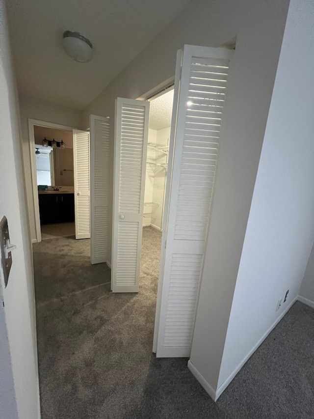 hallway with dark colored carpet