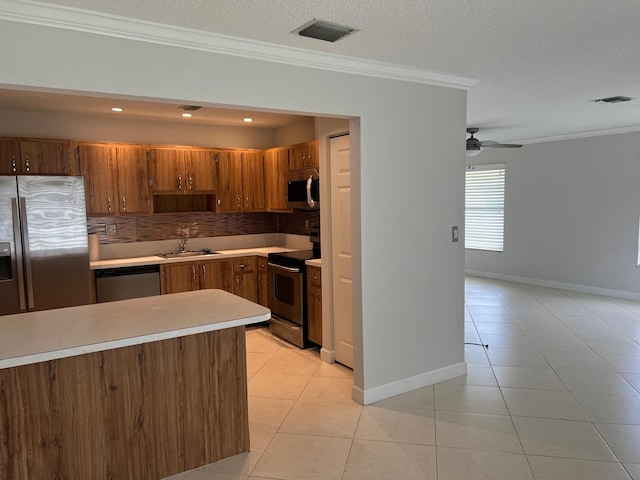 kitchen with decorative backsplash, stainless steel appliances, ornamental molding, and sink