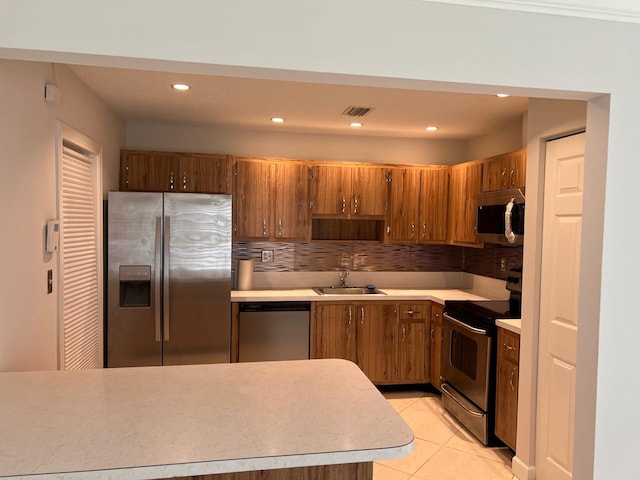 kitchen featuring light tile patterned floors, stainless steel appliances, tasteful backsplash, and sink