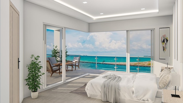 interior space with access to exterior, a tray ceiling, and a water view