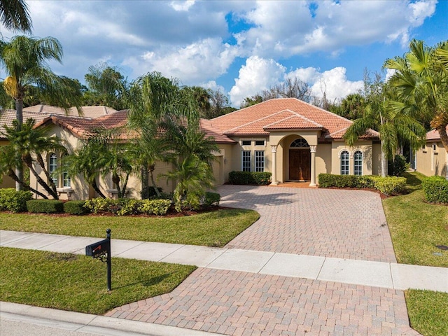 mediterranean / spanish home featuring a front lawn