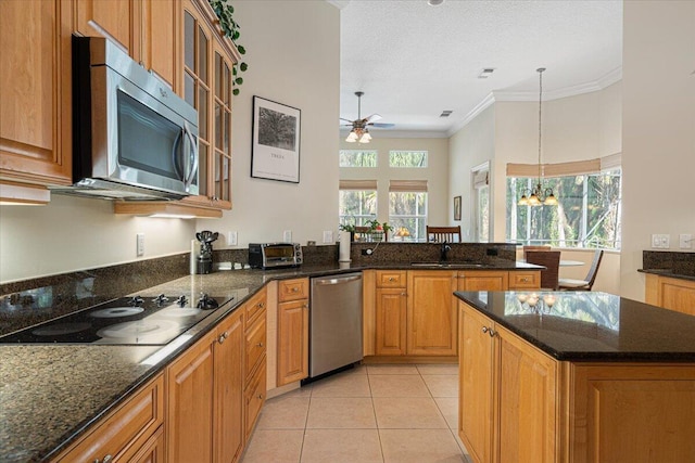 kitchen with sink, crown molding, light tile patterned floors, appliances with stainless steel finishes, and a kitchen island