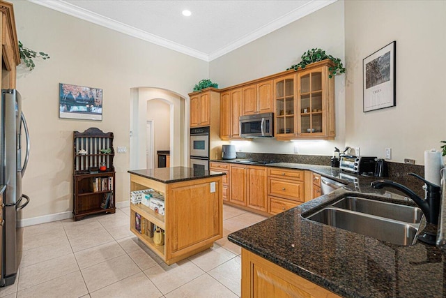 kitchen featuring sink, crown molding, a center island, dark stone counters, and stainless steel appliances