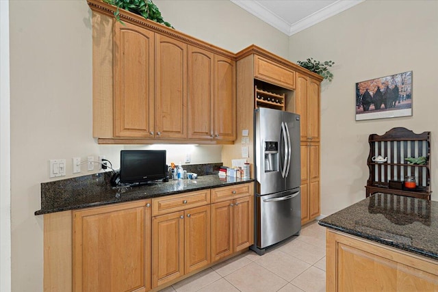 kitchen featuring light tile patterned flooring, ornamental molding, dark stone counters, and stainless steel refrigerator with ice dispenser