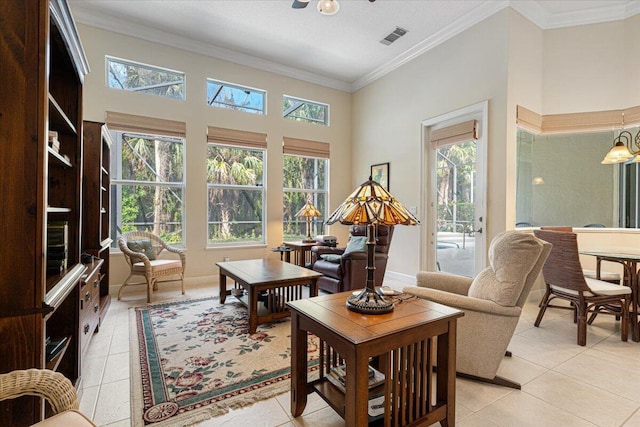 living room featuring a high ceiling, crown molding, light tile patterned floors, and ceiling fan