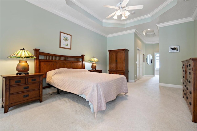 carpeted bedroom featuring ceiling fan, ornamental molding, a raised ceiling, and a closet