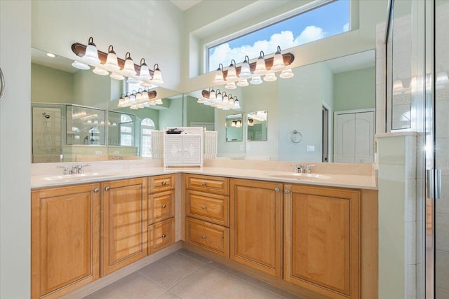 bathroom featuring a healthy amount of sunlight, tile patterned flooring, a shower with door, and vanity