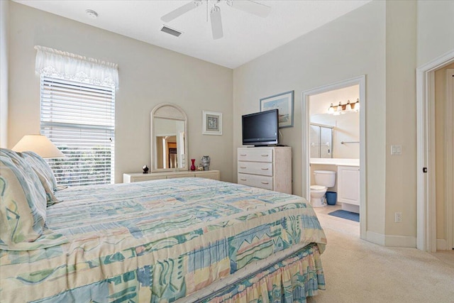 bedroom featuring ceiling fan, connected bathroom, and light carpet