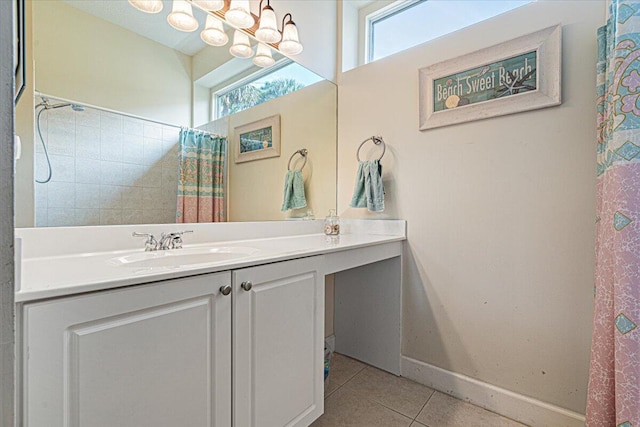 bathroom with an inviting chandelier, plenty of natural light, tile patterned flooring, and vanity