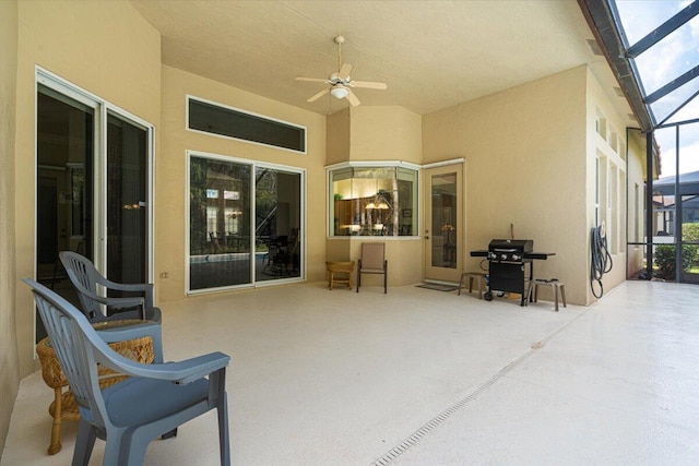 view of patio with ceiling fan and glass enclosure