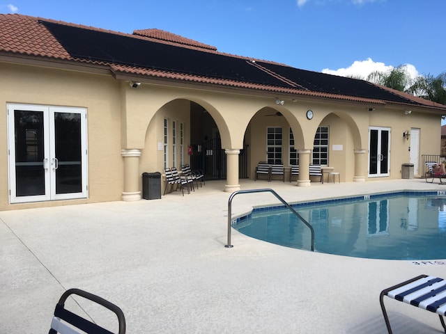 view of swimming pool with a patio and french doors