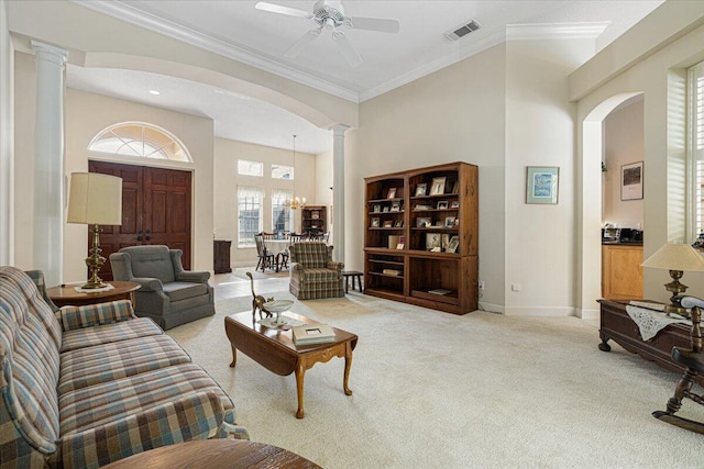 carpeted living room with ornate columns, ornamental molding, a high ceiling, and ceiling fan