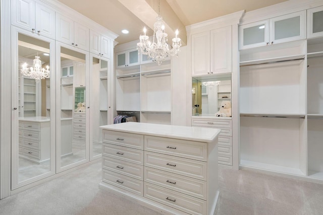 spacious closet with light colored carpet and a notable chandelier