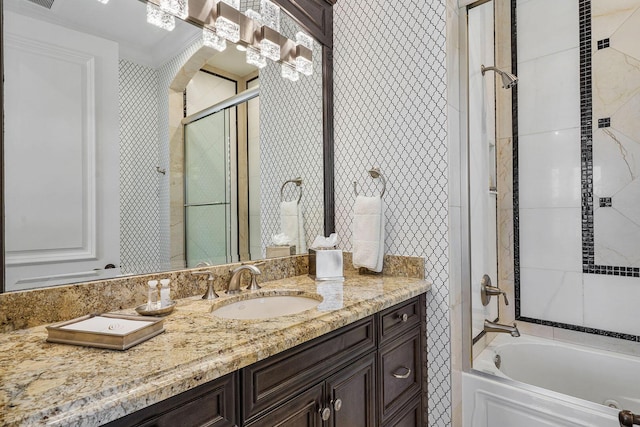 bathroom featuring shower / bath combination with glass door, wallpapered walls, and vanity