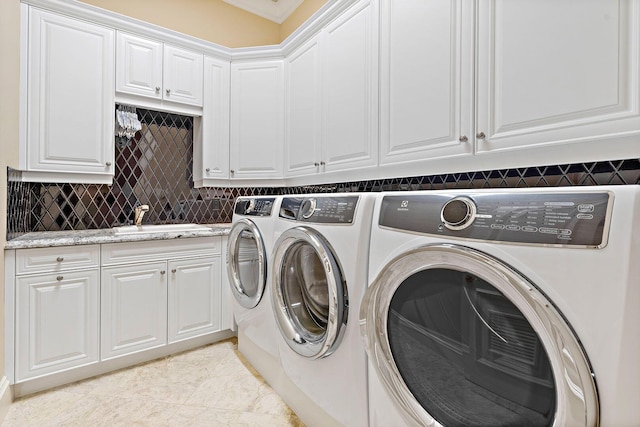 clothes washing area featuring light tile patterned floors, separate washer and dryer, a sink, and cabinet space