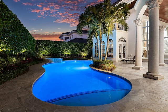 outdoor pool with a patio area and french doors