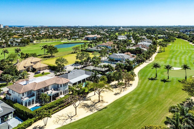 drone / aerial view with a water view, golf course view, and a residential view
