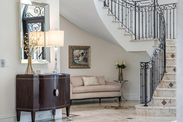 interior space featuring high vaulted ceiling, stairs, marble finish floor, and baseboards