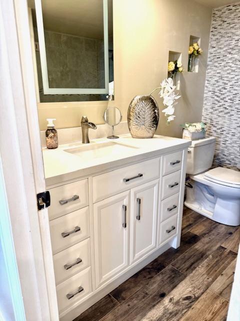 bathroom with vanity, hardwood / wood-style floors, and toilet