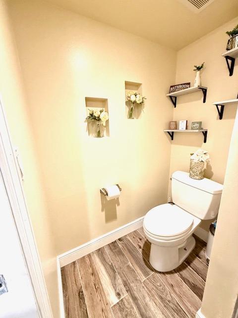 bathroom with wood-type flooring and toilet