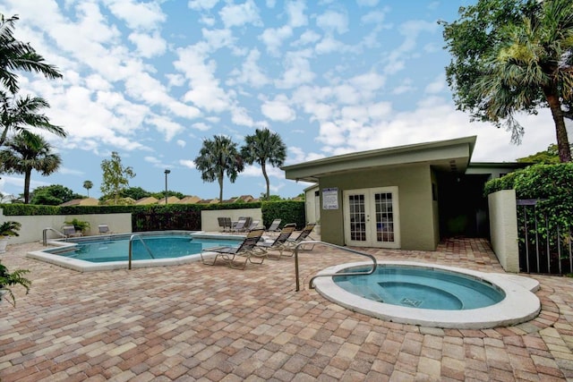 view of swimming pool featuring a community hot tub, a patio area, and french doors