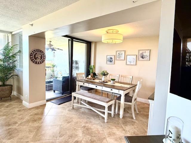 dining room with light tile patterned floors, expansive windows, and a textured ceiling