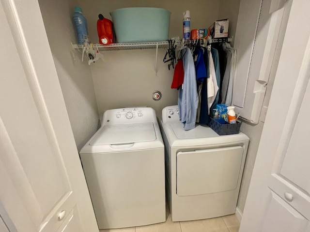 laundry room featuring laundry area, separate washer and dryer, and light tile patterned flooring