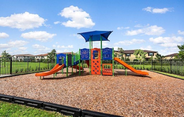 community playground with a residential view and fence