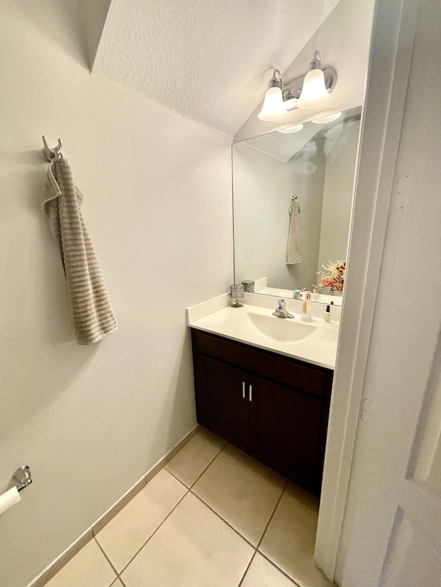 bathroom with tile patterned flooring, baseboards, a textured ceiling, and vanity