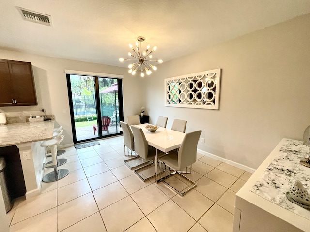 dining space featuring light tile patterned floors, visible vents, baseboards, and an inviting chandelier