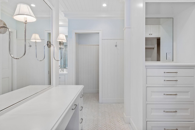 bathroom with a shower, vanity, and ornamental molding