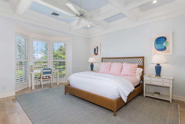 bedroom featuring coffered ceiling, light hardwood / wood-style floors, ceiling fan, and beam ceiling