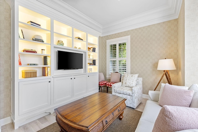 living room featuring built in shelves, ornamental molding, and light hardwood / wood-style floors