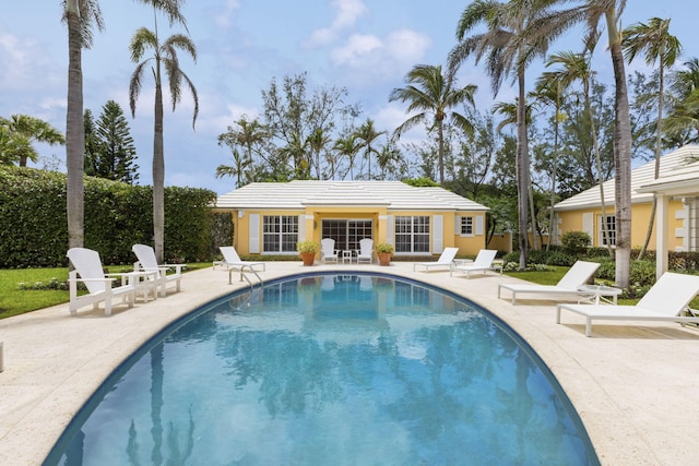 view of swimming pool featuring an outbuilding and a patio