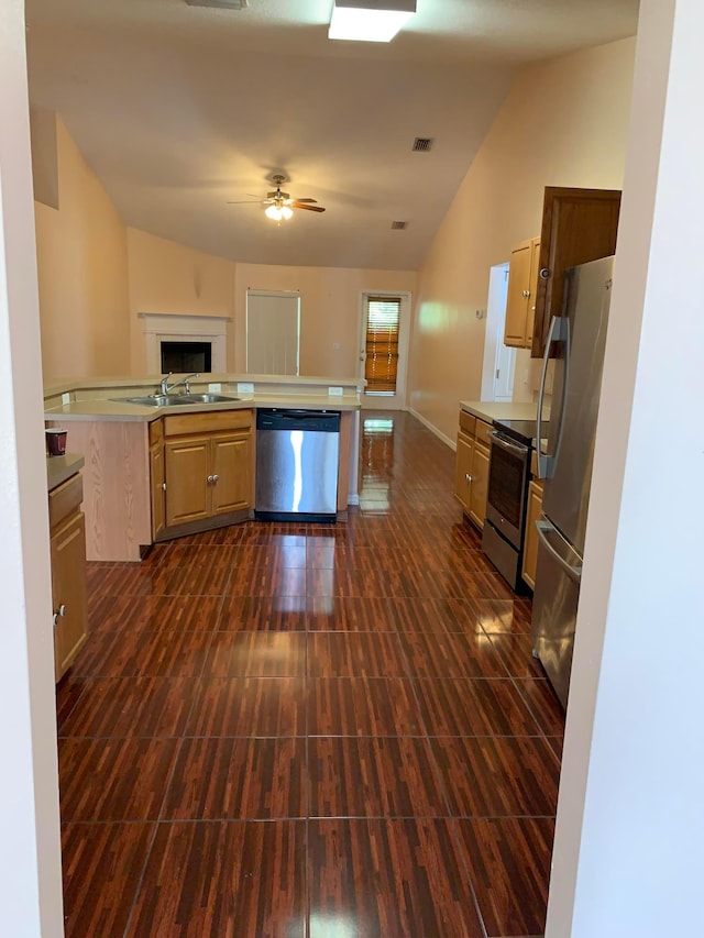 kitchen featuring lofted ceiling, stainless steel appliances, ceiling fan, and sink