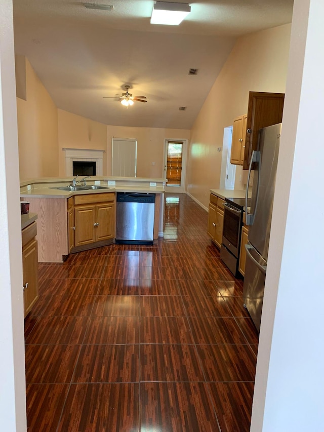 kitchen with appliances with stainless steel finishes, lofted ceiling, ceiling fan, and sink