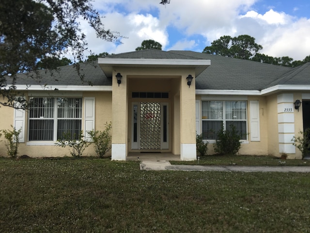 view of exterior entry with a lawn